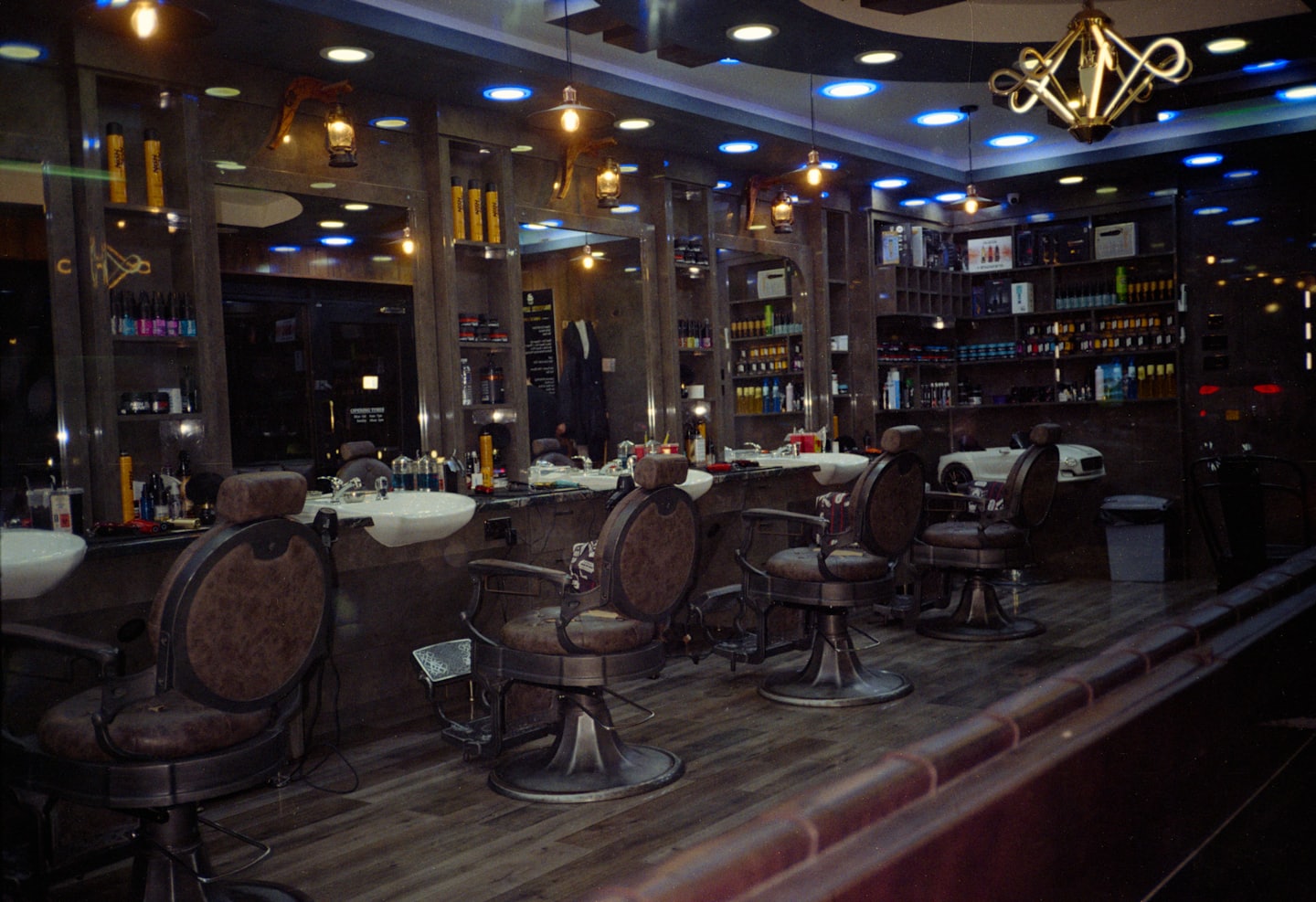Modern barbershop with vintage barber chairs and shelves of products.