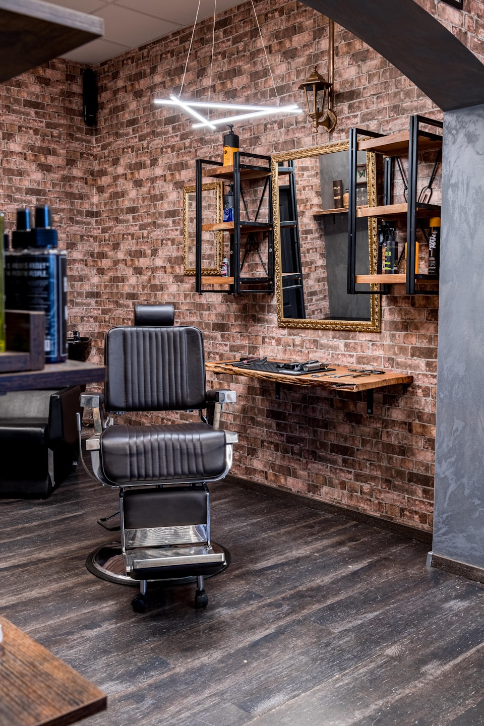Modern barbershop with barber chair and brick wall.