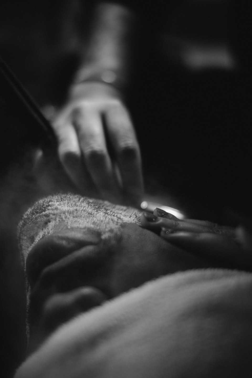 Barber shaving a client's head with a straight razor.